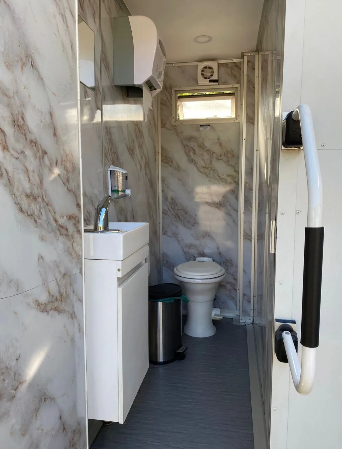 Interior del tráiler baño móvil premium Maihue con vanity, espejo e iluminación cálida