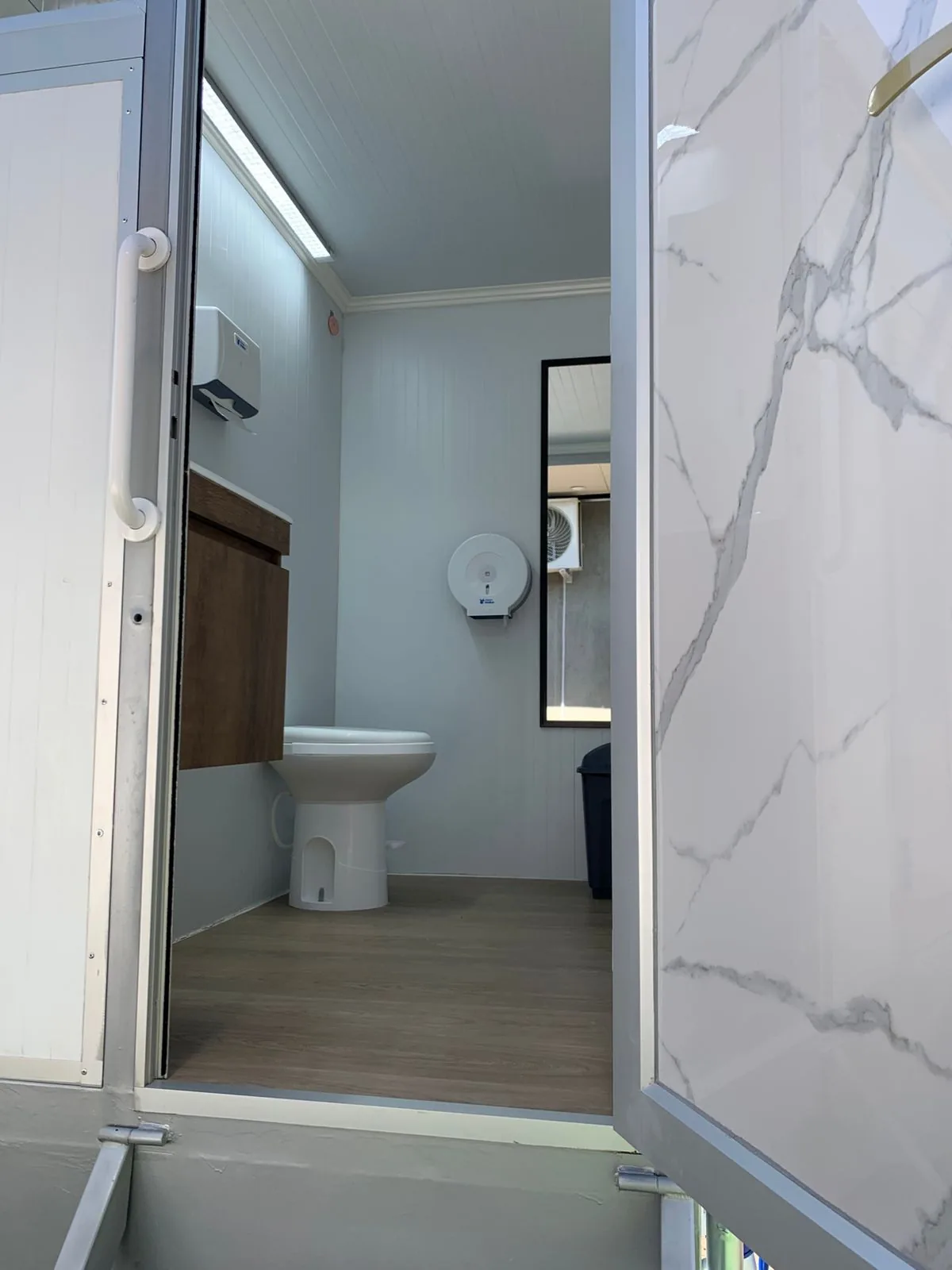 Interior del tráiler Maihue con vanity iluminado, espejo y acabados premium