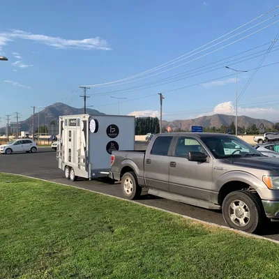 Camioneta Ford remolcando un tráiler de baños móviles Maihue en la carretera camino a un evento